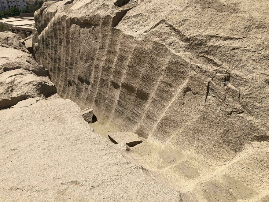 Strange things happening on Earth: a massive rock formation with peculiar, uniform cut marks, resembling ancient quarrying.