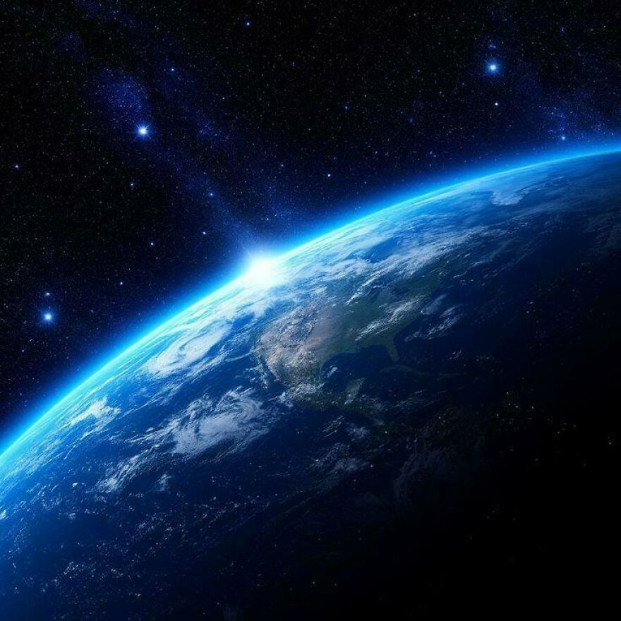 Strange things happening on Earth: A breathtaking view of Earth from space, with the sun rising over the horizon.
