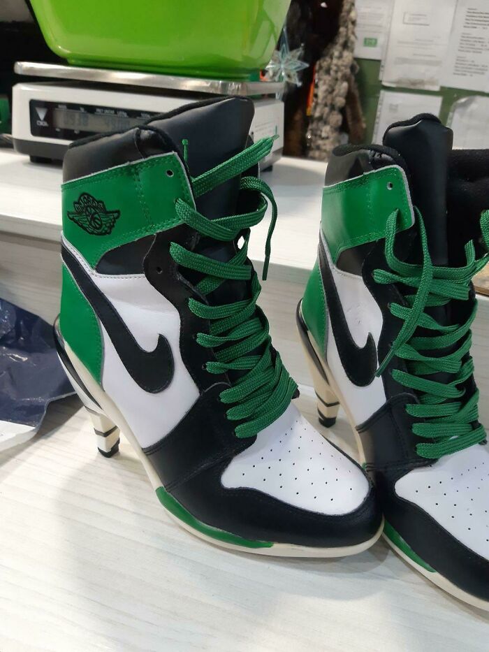 High-heeled shoes designed to look like green, white, and black sneakers, a hilariously bad fashion crime.