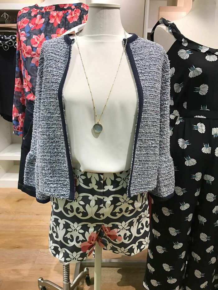 A mannequin displaying a collection of clothes, including a tweed jacket, white top, and patterned shorts. Not a fashion crime.