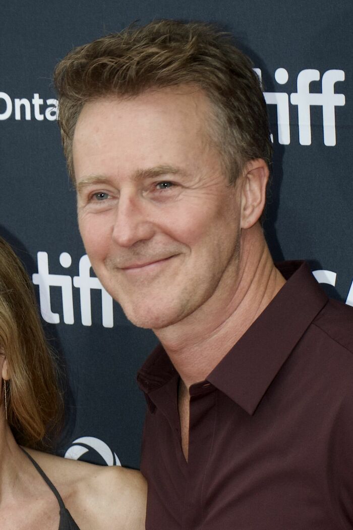 Edward Norton, a distinguished actor, smiling at an event, highlighting his impactful career highlights in film.