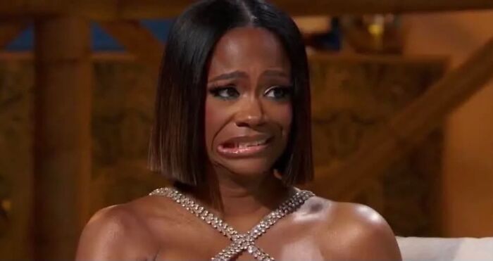 A woman with short dark hair and a sparkly top looks upset and makes a face. Women share what they put up with before walking away.