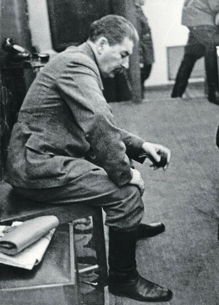 Beautiful photo from history of Joseph Stalin sitting, head down, holding a small item in his hand