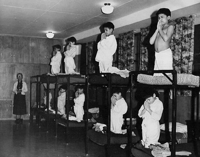 A historical photo of children praying in a dormitory, a heartbreaking and interesting moment from history.
