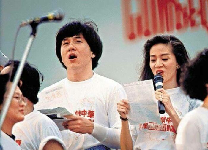 A historical photo of Jackie Chan and a woman singing, an interesting and beautiful moment from history.