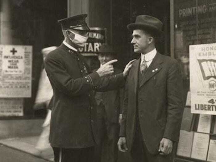 Heartbreaking historical photo of a police officer confronting a man without a mask during the influenza, interesting.