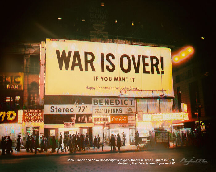 A large billboard in Times Square at night displaying War Is Over! If You Want It, a beautiful piece of history.