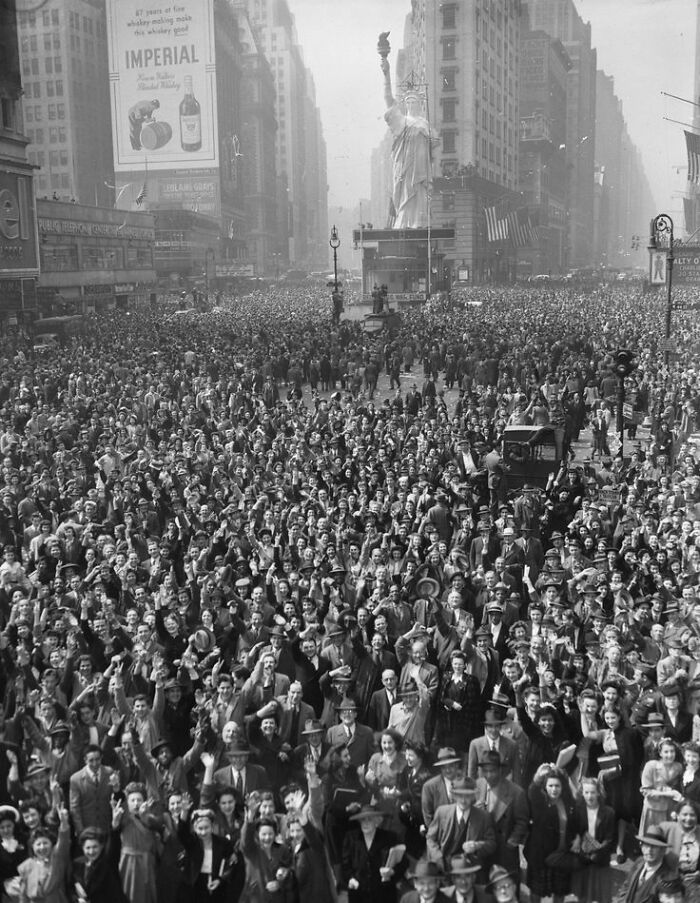 A black and white photo showing a massive crowd of people celebrating in Times Square, an interesting moment in history.