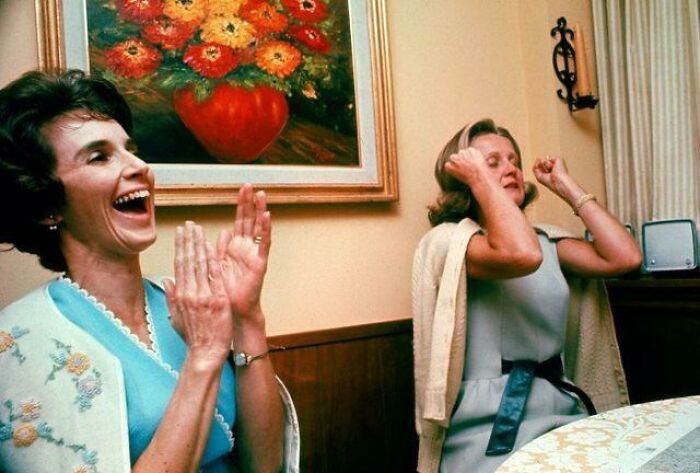 Two women reacting excitedly to something, one clapping. Beautiful photos from history showing human emotion.
