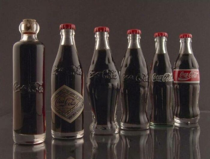 Evolution of Coca-Cola bottles shown in a row. Interesting photos from history.