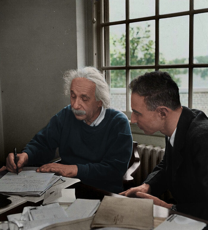 Albert Einstein writing while a younger man looks on. Interesting photos from history.