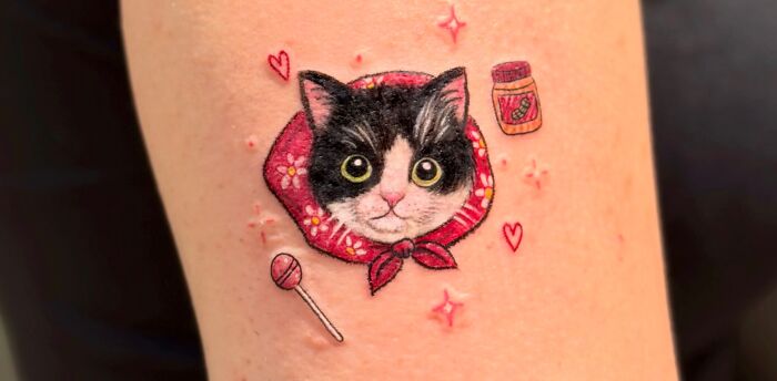 Cute crayon drawing-inspired tattoo of a cat with a babushka scarf, candy, and a jar, celebrating childhood creativity.