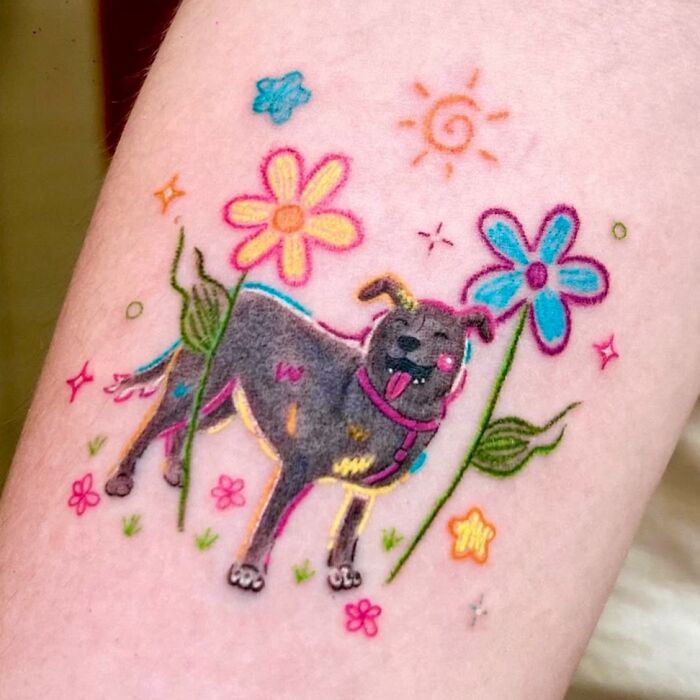 Cute dog surrounded by crayon drawing inspired flowers and sun tattoo.