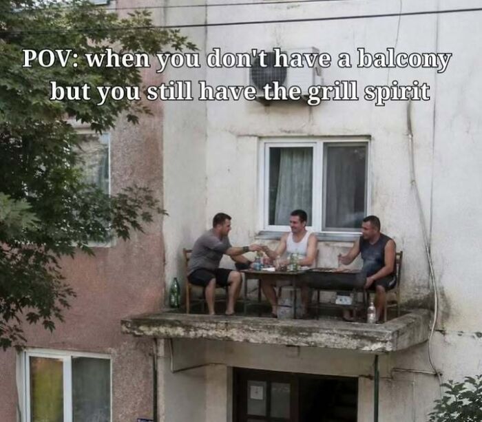 Three men from Eastern Europe grilling on a small concrete ledge outside a window, demonstrating their unique grill spirit.