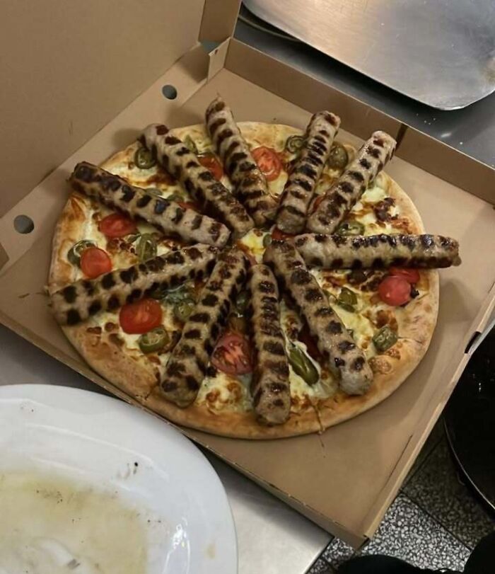 A pizza topped with numerous grilled sausages, a meme showing Eastern European preferences.