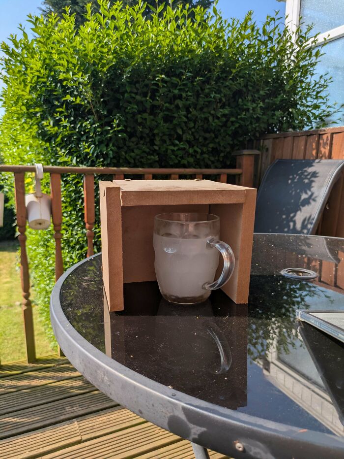 A glass of iced water inside a wooden box, showing people putting effort into renovating homes and small projects.