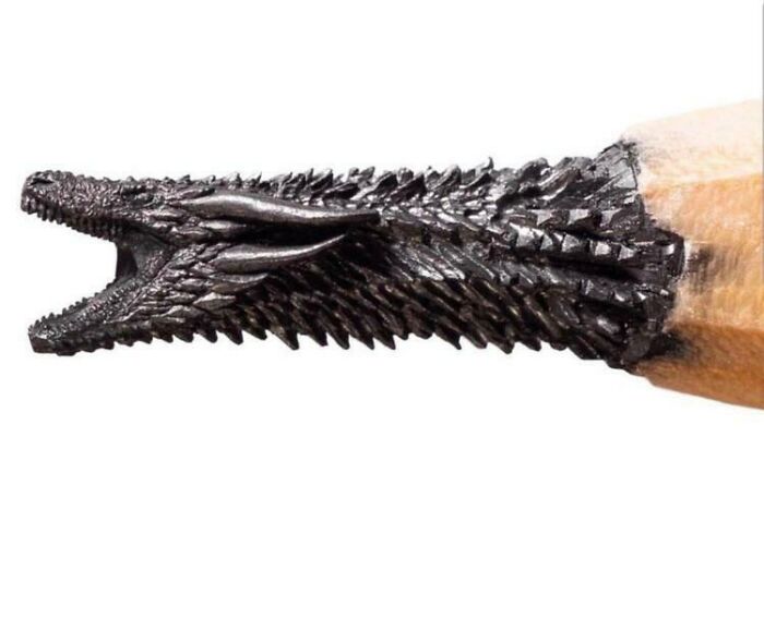 A detailed carving of a dragon head made from a pencil tip, a fascinating find demonstrating intricate art.