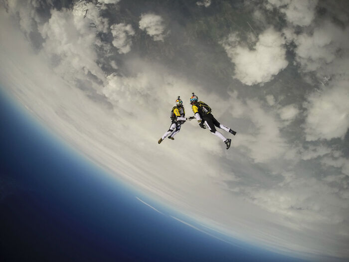 Two skydivers freefalling high above Earth, capturing fascinating finds and showing a unique perspective.