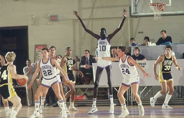 Fascinating finds: A very tall basketball player (#10) on a court, towering over other players during a game.