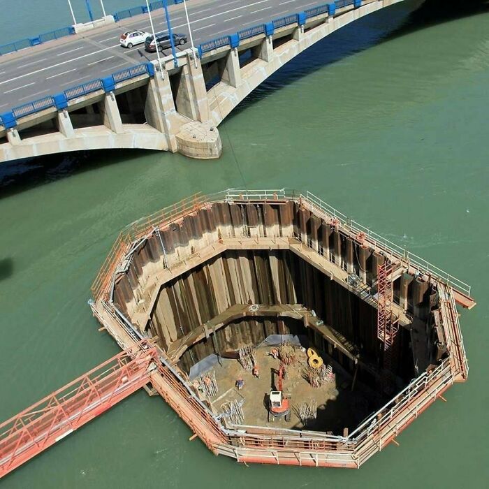 A fascinating find: Construction site of a bridge pillar, showing a large coffer dam in the water.