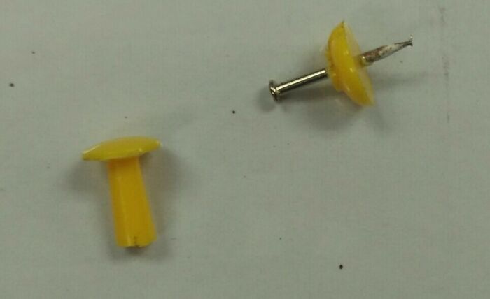 A broken pushpin with the plastic cap detached from the metal pin, a fascinating find that the internet can show us.