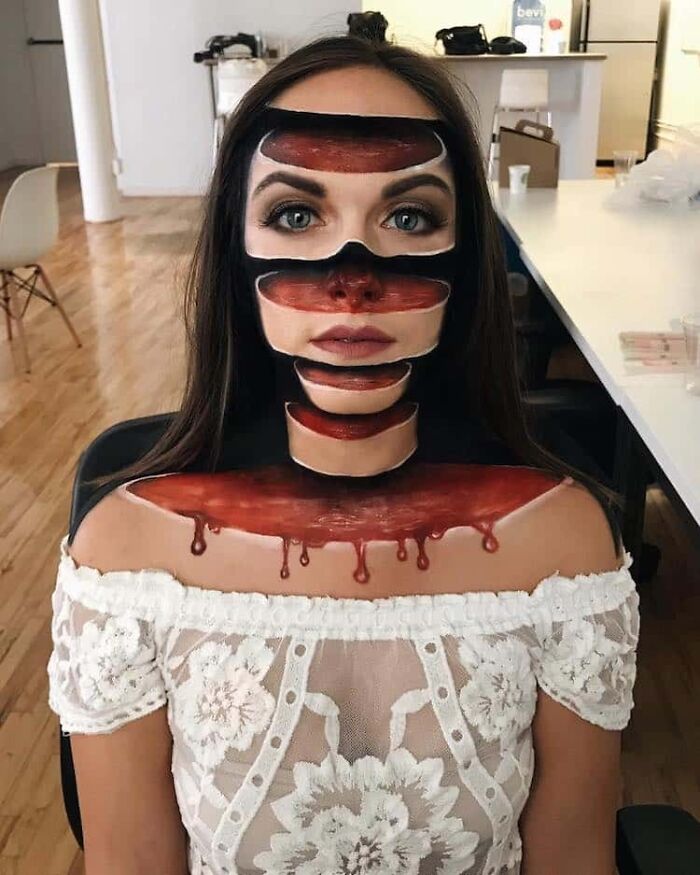 A woman with incredible illusion makeup, making her face appear sliced. A fascinating find.