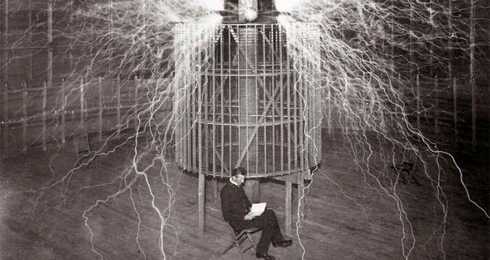 Nikola Tesla sitting calmly in his Colorado Springs lab amidst huge electrical discharges, a fascinating find.