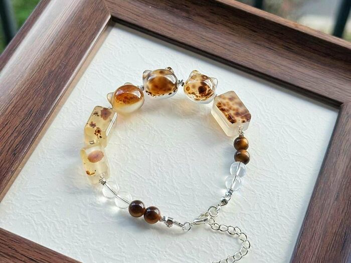 A handmade bracelet featuring various natural stone beads, including cat-shaped and rectangular agate, and tiger's eye beads. A charming handmade project.