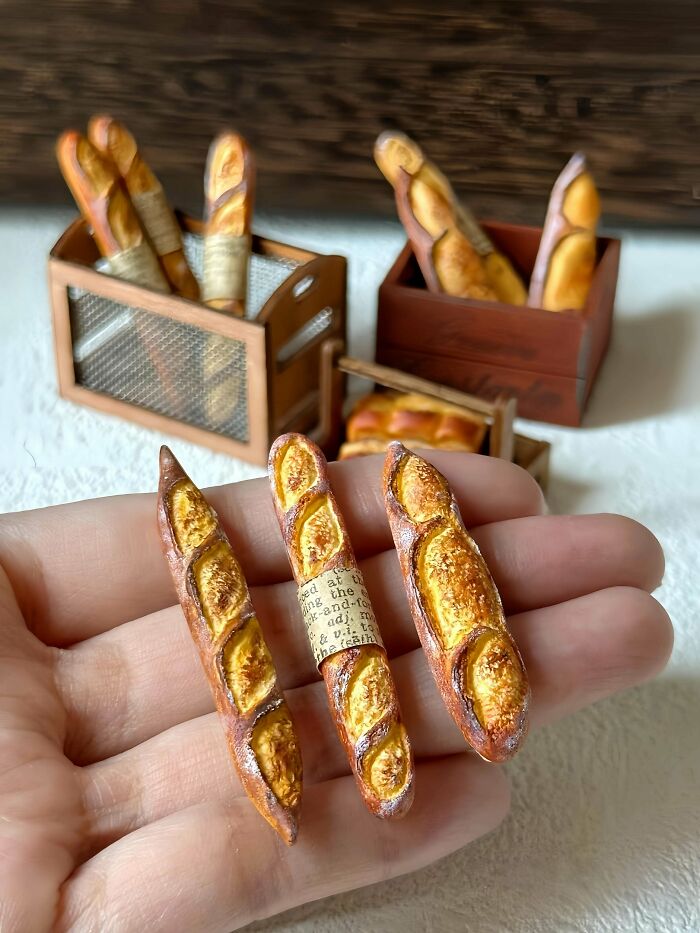 Three miniature baguettes, artfully crafted and held in a hand, part of stunning handmade projects.