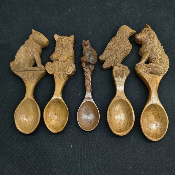 Collection of handmade projects: five intricately carved wooden spoons with animal and bird handles, on a dark surface.