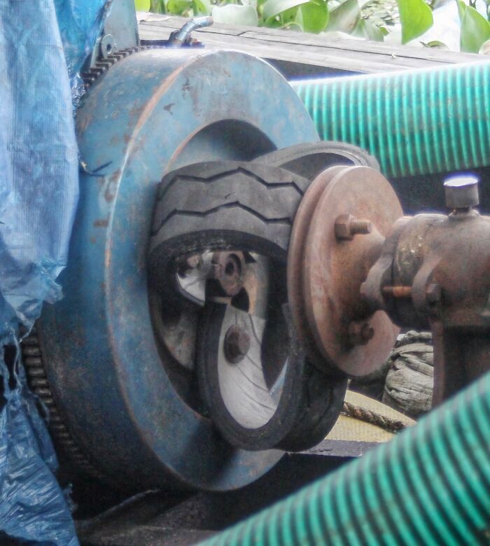 A close-up of a clever solution made from random junk: a blue machine with repurposed tires as parts.