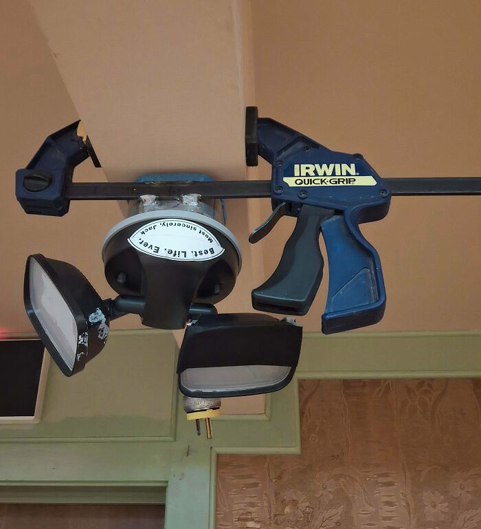 An Irwin quick-grip clamp holding a light fixture, a clever solution for random junk.