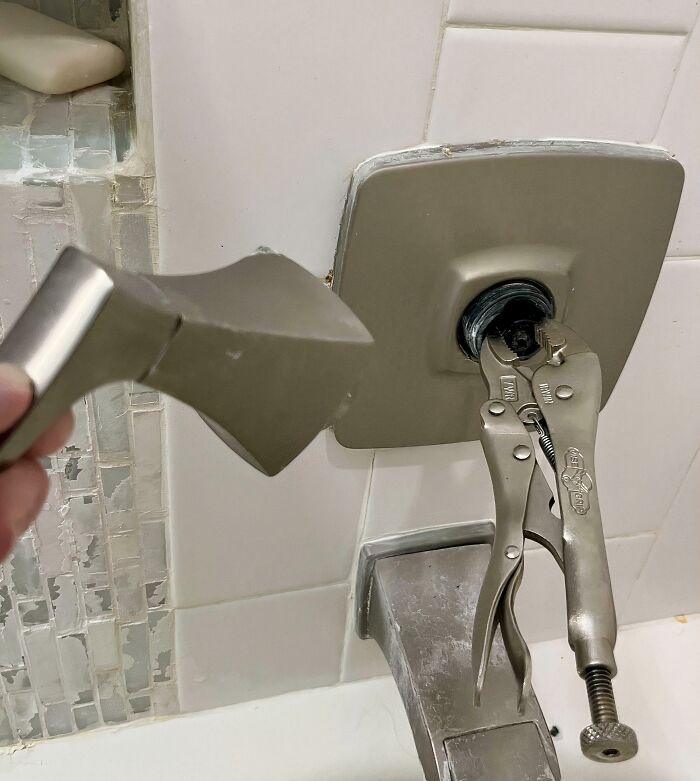 Vice grips used as a clever solution to remove a shower faucet handle, revealing the internal plumbing.
