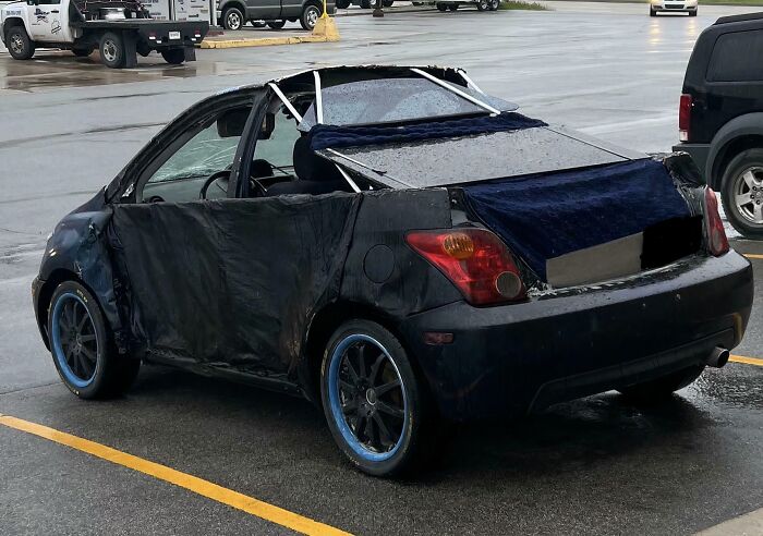 A car with its roof removed and a blue blanket covering the back, demonstrating clever solutions.