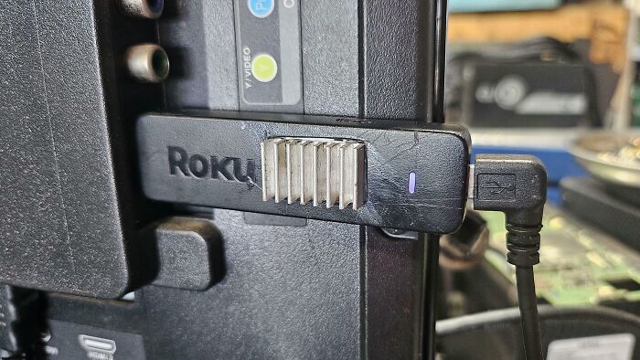 A Roku stick with a small heatsink attached, demonstrating a clever solution to prevent overheating.