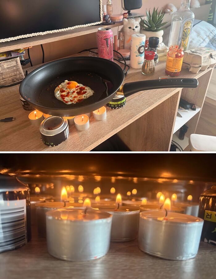 An egg frying in a pan heated by multiple small candles on a desk, a clever solution from random junk.
