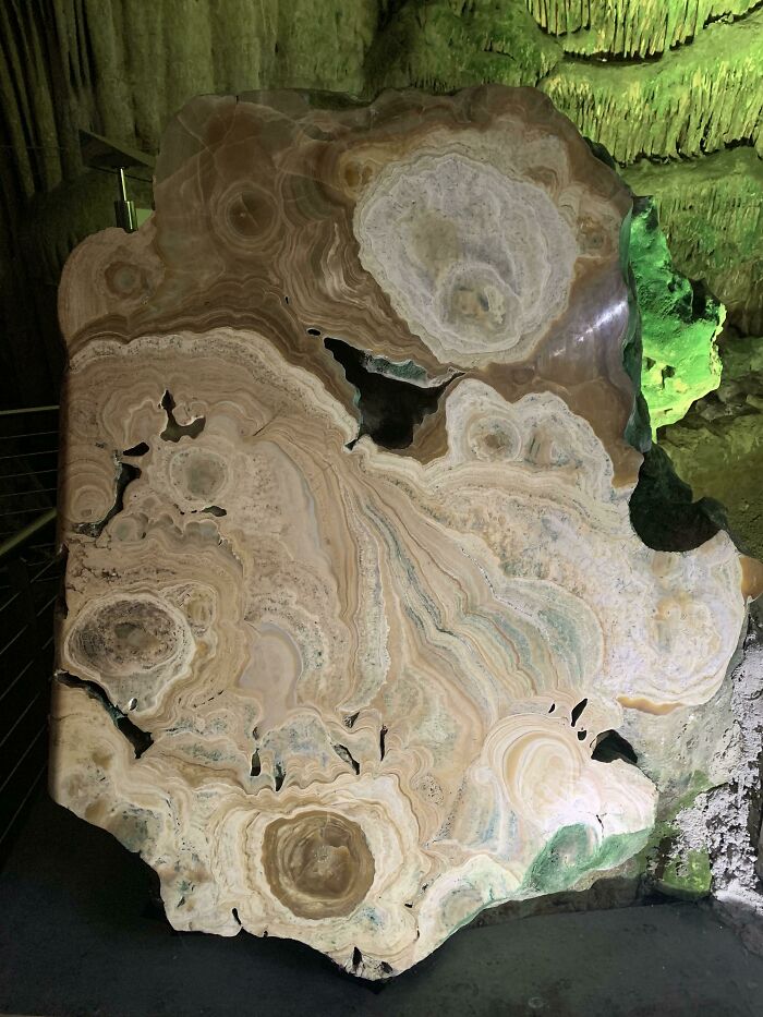 Surprising photo of a large, polished rock object cut in half, revealing intricate geological patterns and colors.