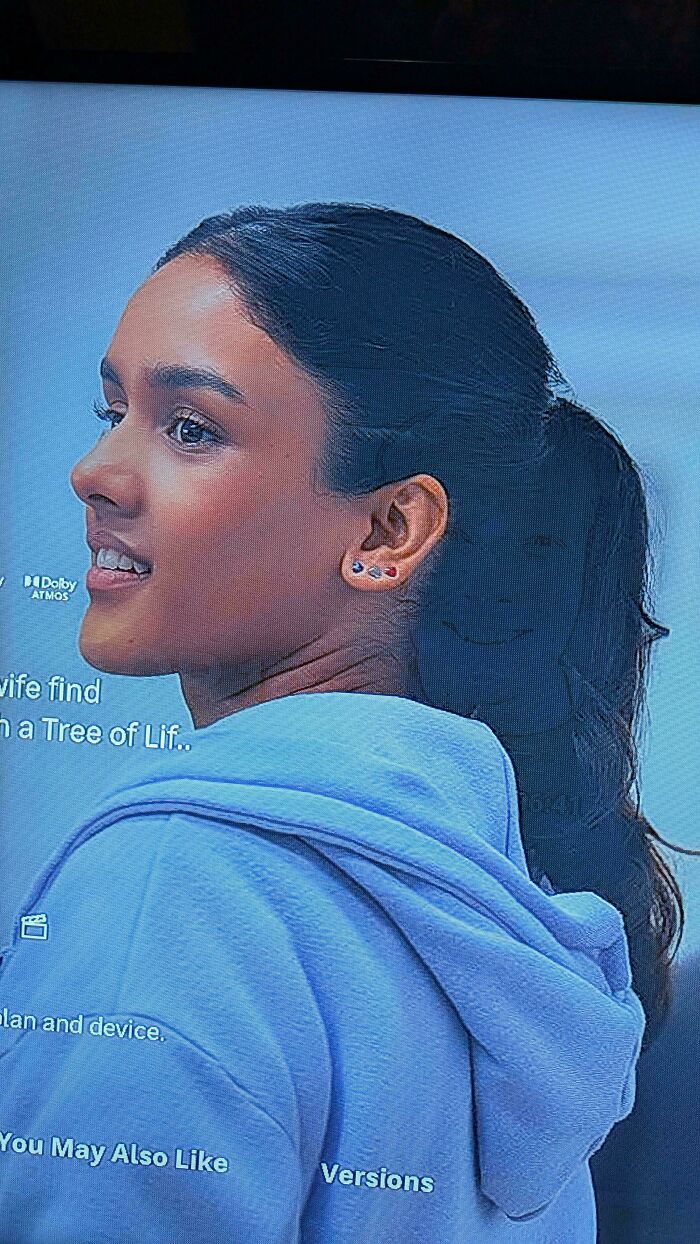 Screenshot of a woman on a screen with unique earrings, one of many weird internet moments.