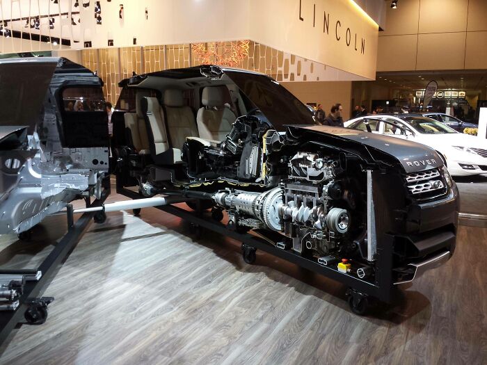 A black Range Rover car cut in half, exposing its engine and interior components, an interesting photo of an object cut in half.