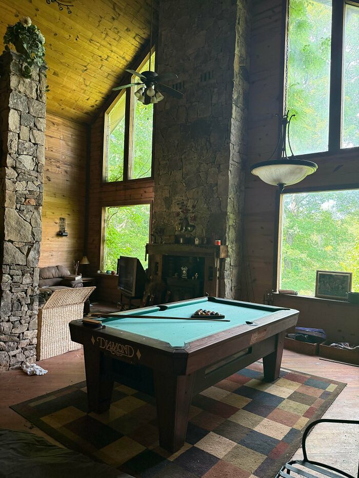People exploring abandoned places found an unexpected large room with a pool table and stone fireplace.