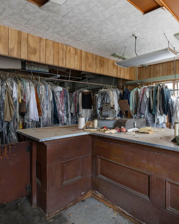 People exploring abandoned places found an unexpected abandoned dry cleaning business with clothes on racks.