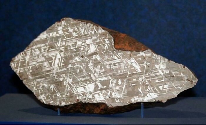 Interesting photo of a meteorite cut in half, showcasing its intricate crystalline patterns.