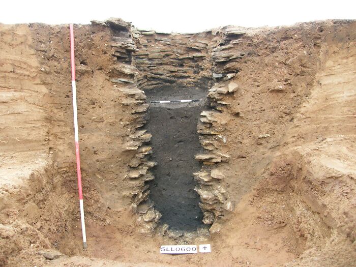 Interesting and surprising photos of an archaeological trench, cut in half to reveal the earth layers and stone structure.