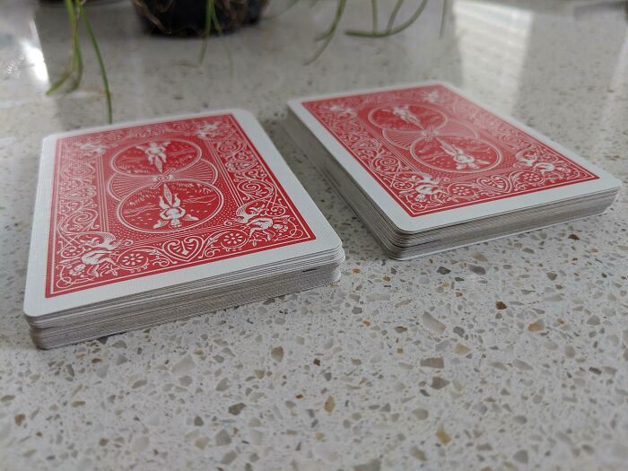 Interesting and surprising photos of two decks of playing cards, cut in half to reveal their thickness.