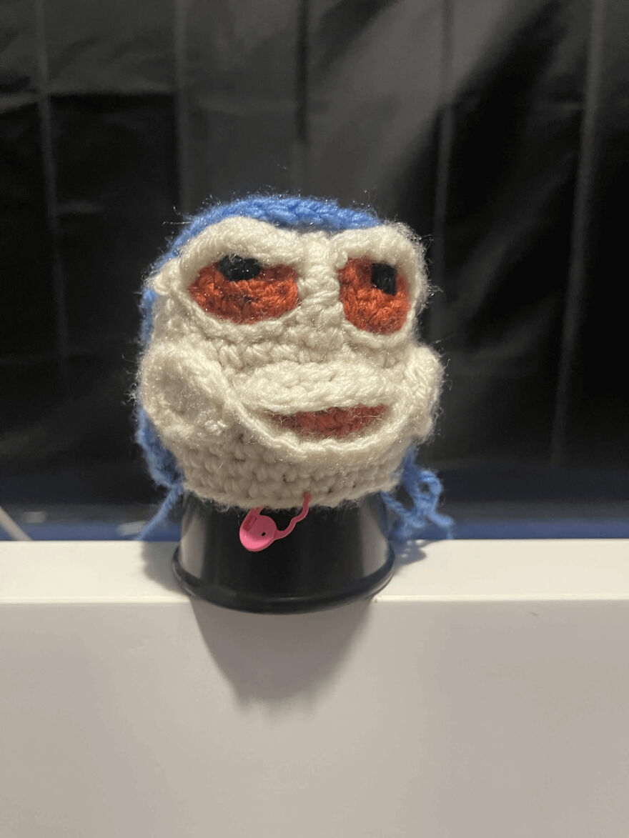 A peculiar blue and white crochet creation with red eyes, showing an unintended craft project outcome.