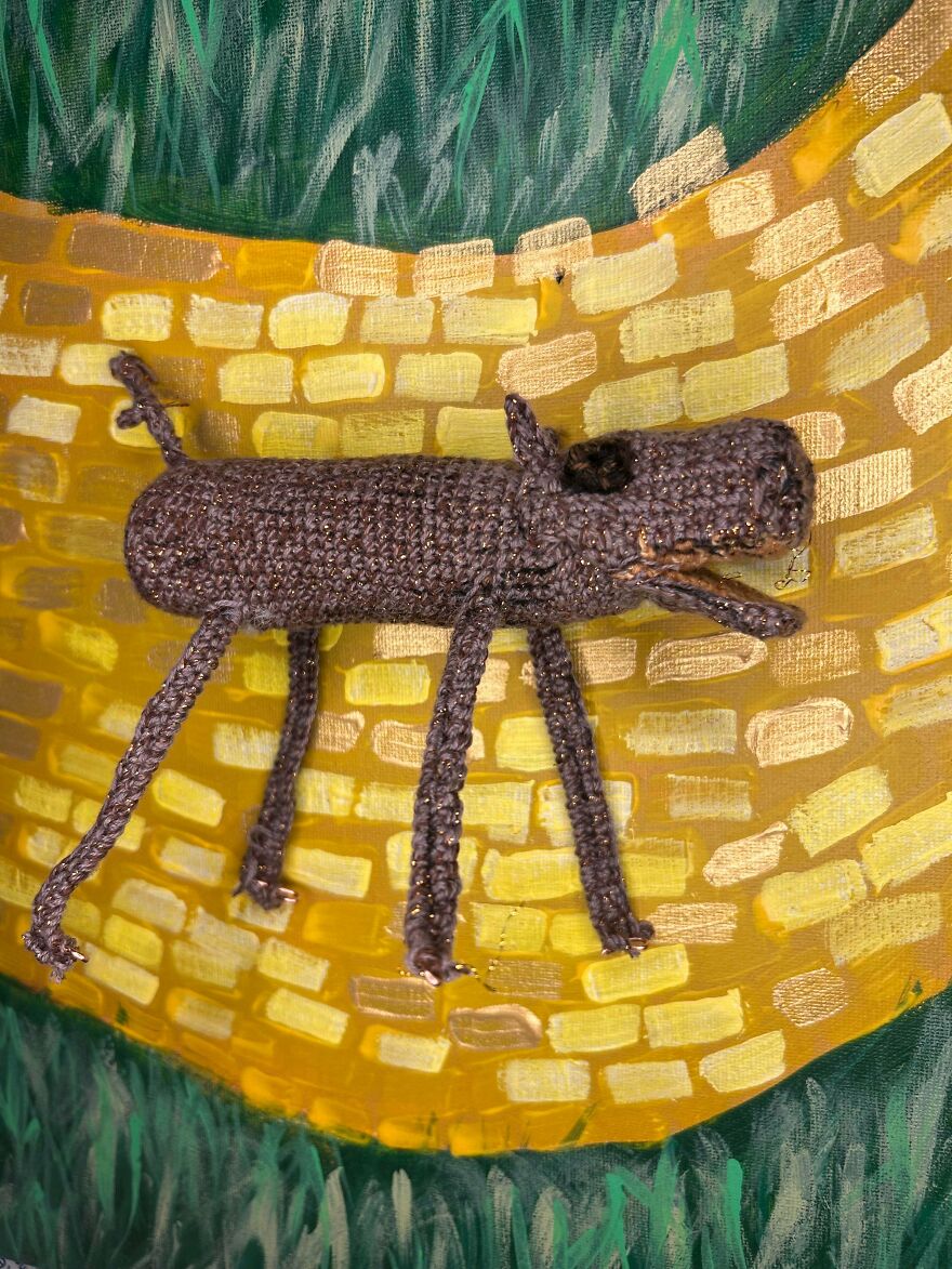 A brown crochet creation resembling a dog on a yellow brick road painting, an artistic crochet creation.
