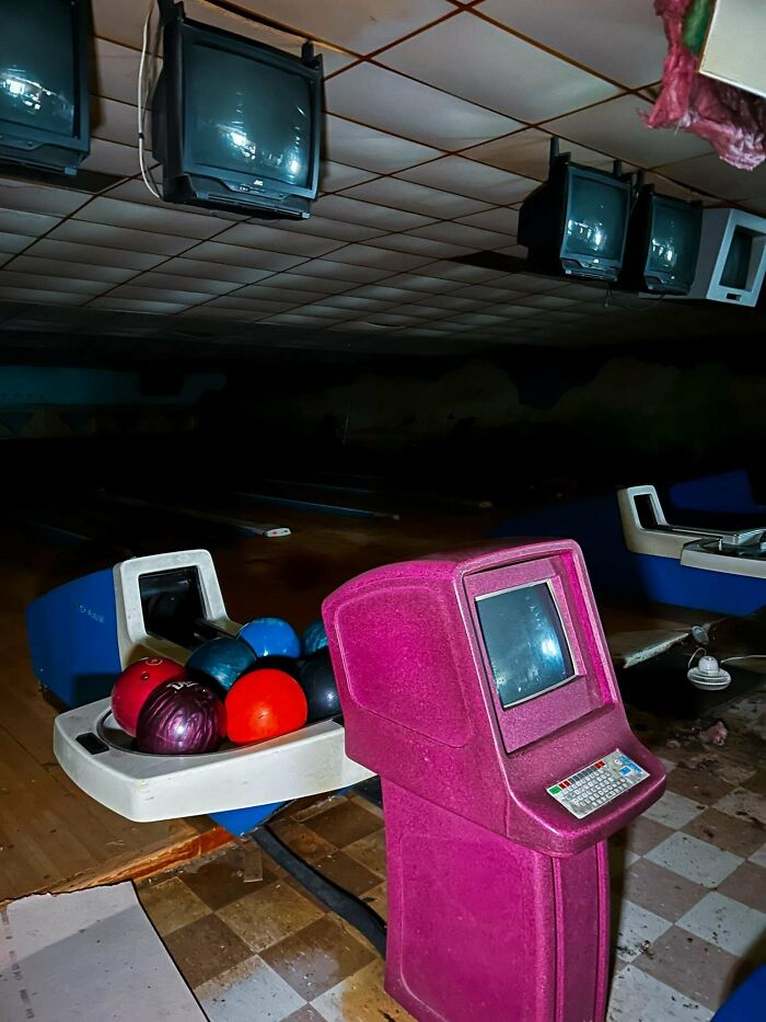 Exploring abandoned places reveals an old bowling alley with vintage screens, balls, and scoring consoles.