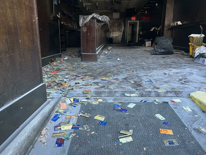 A messy, empty room with debris and cards scattered on the floor, exploring abandoned places.