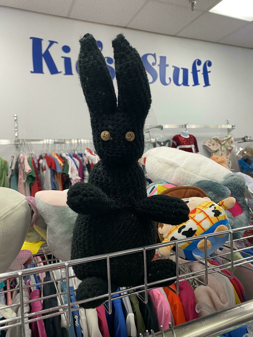 A tall black crochet creation with long ears and button eyes, sitting in a store called Kids Stuff, a craft project.
