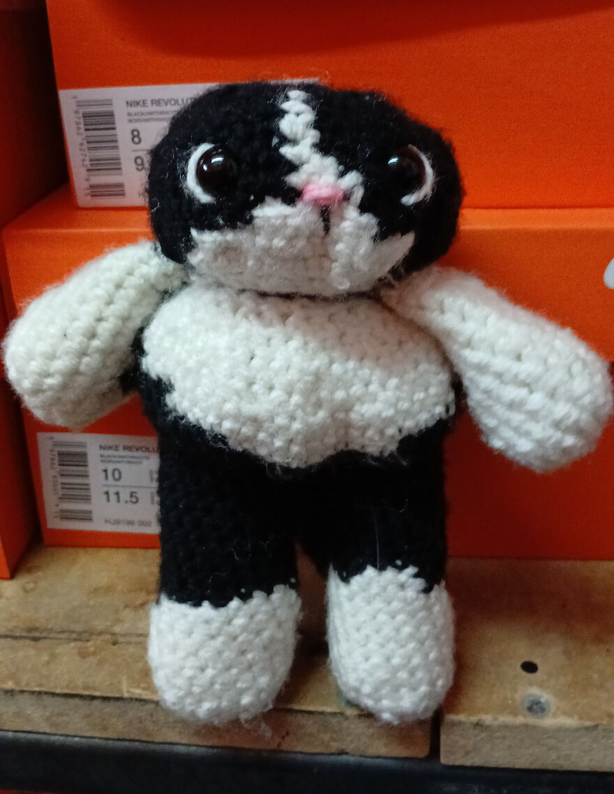 A black and white crocheted cat-like creature with big eyes, a craft project that didn't turn out as intended.